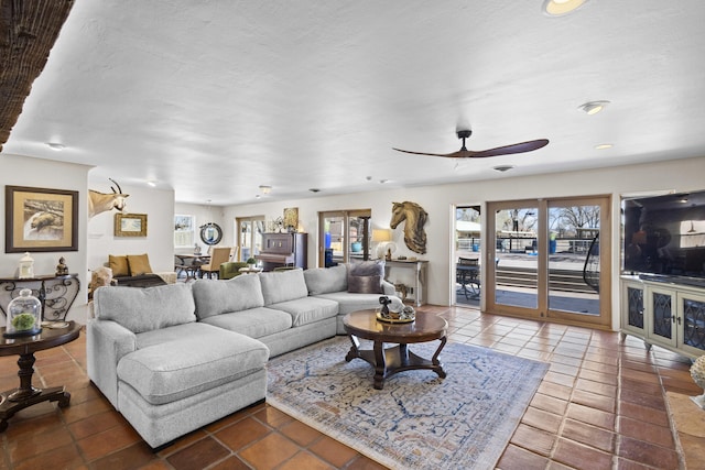 tiled living room with a healthy amount of sunlight and ceiling fan