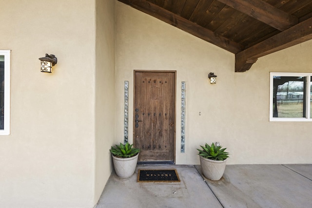 doorway to property featuring stucco siding