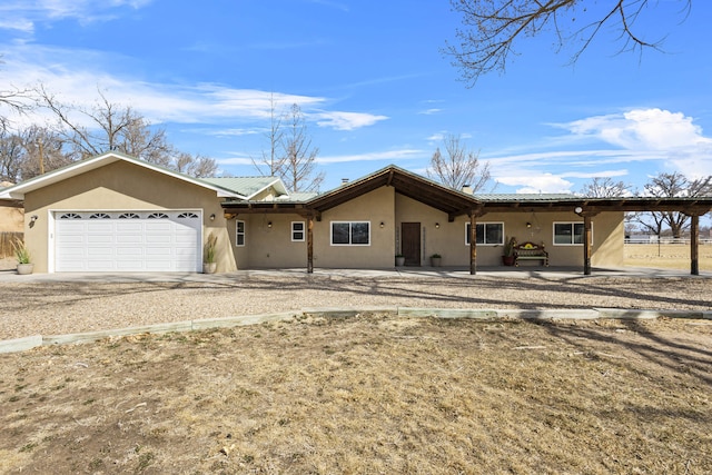 ranch-style home featuring a garage, driveway, and stucco siding