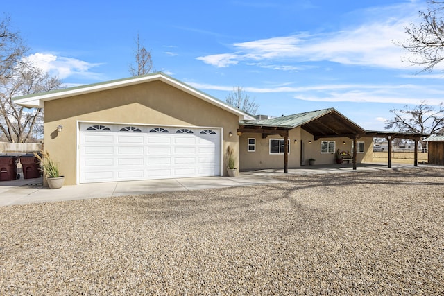 ranch-style house featuring stucco siding, a garage, driveway, and fence