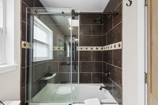 bathroom with combined bath / shower with glass door