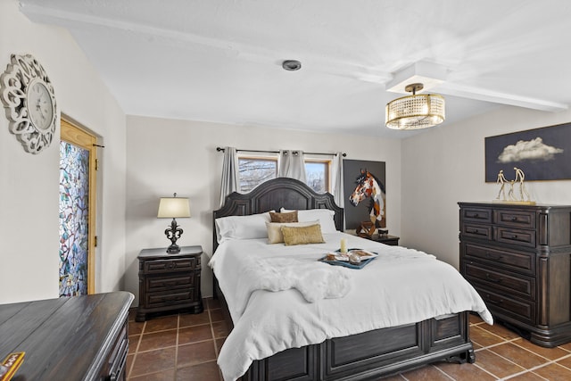 bedroom with an inviting chandelier and dark tile patterned flooring