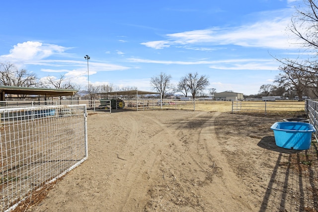 view of yard featuring an outbuilding, a rural view, and an exterior structure