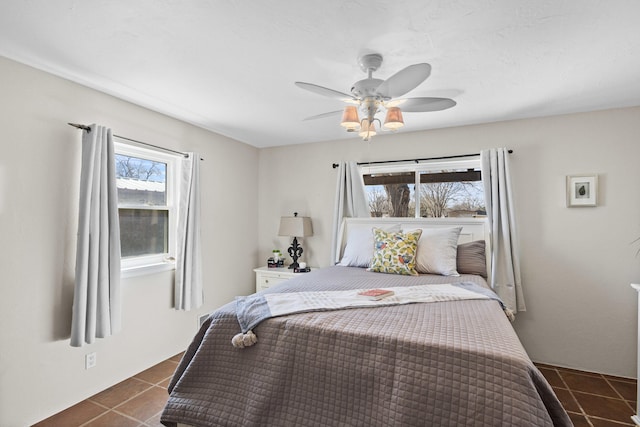 bedroom with dark tile patterned floors and ceiling fan