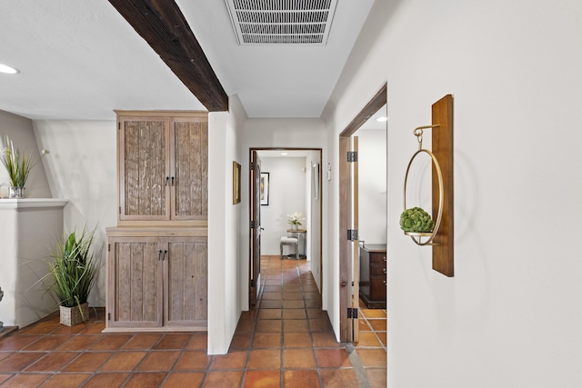 hall with beam ceiling, visible vents, recessed lighting, and dark tile patterned flooring