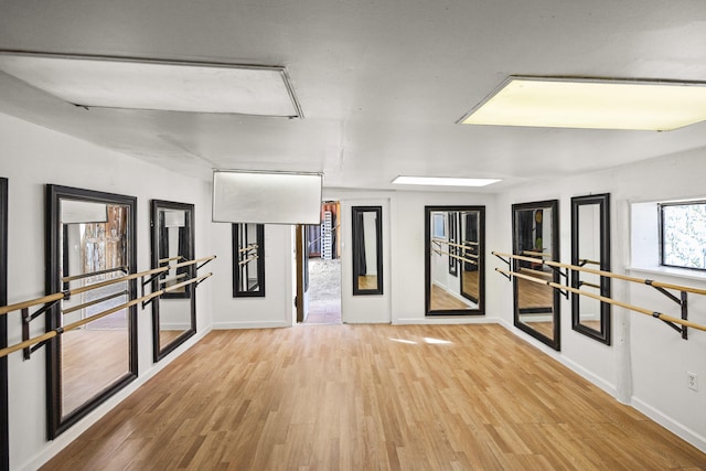 empty room featuring baseboards, attic access, and wood finished floors