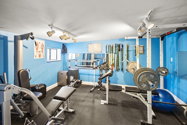 gym featuring track lighting and baseboards