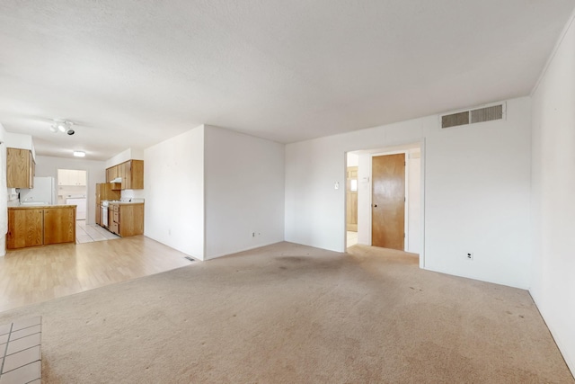 unfurnished living room featuring light colored carpet and visible vents