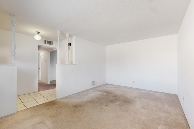 empty room with tile patterned floors, visible vents, and carpet