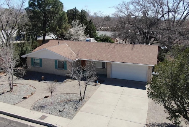 single story home featuring concrete driveway, a garage, and brick siding