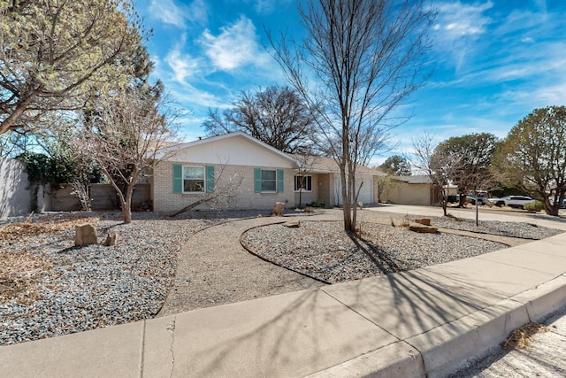 ranch-style home featuring concrete driveway, an attached garage, and brick siding