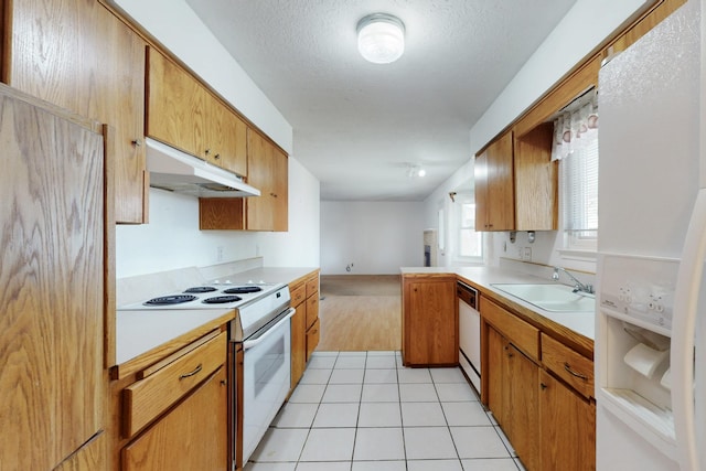 kitchen featuring white appliances, light tile patterned floors, a sink, light countertops, and under cabinet range hood