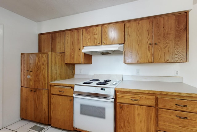 kitchen with light countertops, brown cabinets, under cabinet range hood, and white range with electric stovetop