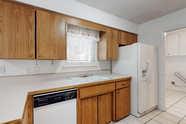 kitchen with a sink, white appliances, light tile patterned flooring, and light countertops