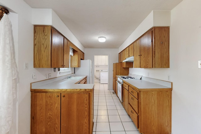 kitchen featuring under cabinet range hood, white appliances, washer / clothes dryer, and light countertops