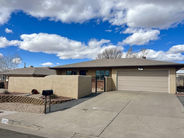 view of front of home featuring concrete driveway, an attached garage, a fenced front yard, and stucco siding