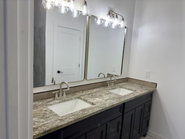 bathroom featuring a sink, baseboards, and double vanity