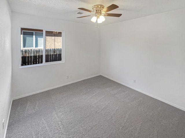 carpeted spare room with baseboards and a ceiling fan