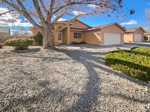 ranch-style home with stucco siding, an attached garage, and concrete driveway