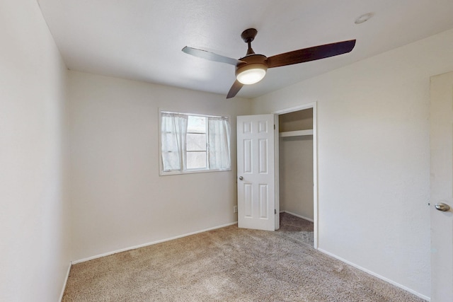 unfurnished bedroom with light colored carpet, a ceiling fan, and baseboards