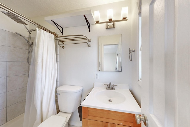 full bathroom featuring vanity, toilet, and a tile shower