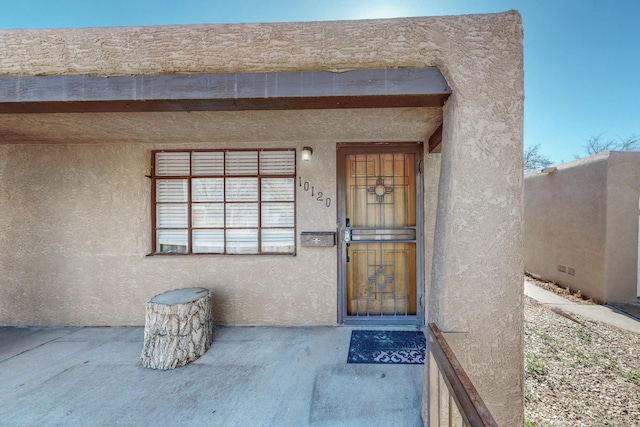 property entrance featuring stucco siding