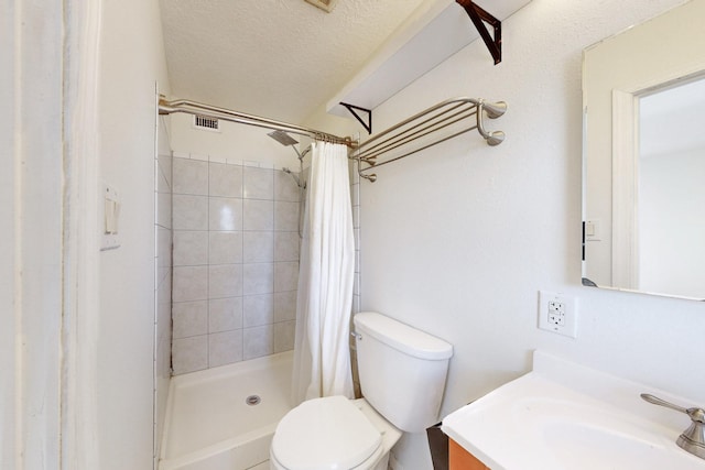 bathroom with toilet, a stall shower, vanity, and a textured ceiling