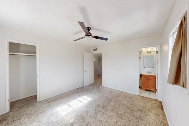 unfurnished bedroom with visible vents, ceiling fan, a closet, ensuite bathroom, and light colored carpet