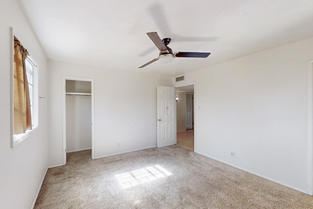 unfurnished bedroom featuring a closet, visible vents, a ceiling fan, and carpet floors