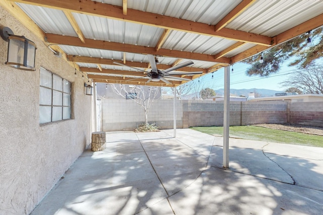 view of patio with ceiling fan, a mountain view, and a fenced backyard