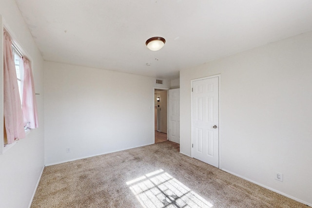 unfurnished bedroom with carpet and visible vents