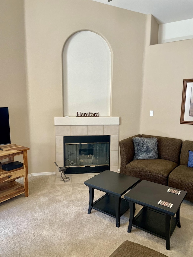 carpeted living area featuring a fireplace and baseboards