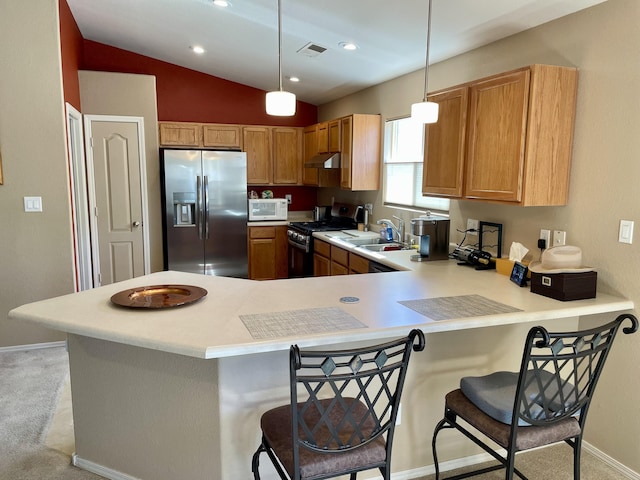 kitchen featuring a sink, appliances with stainless steel finishes, a peninsula, and light countertops