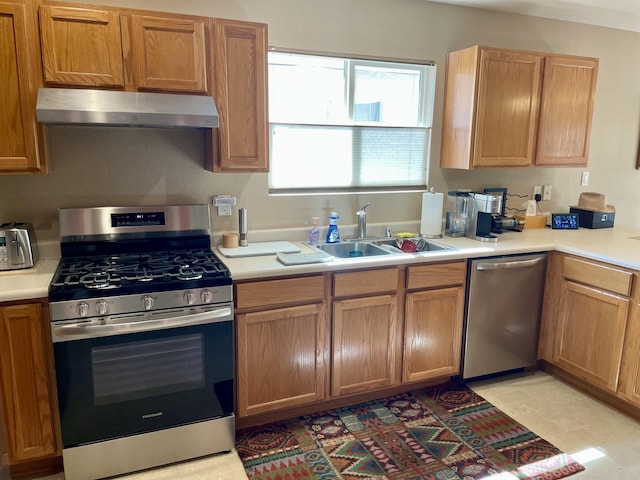 kitchen with a sink, light countertops, wall chimney range hood, and stainless steel appliances