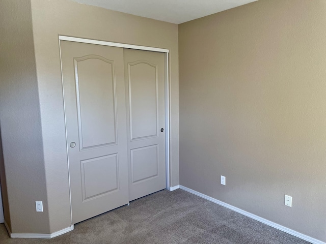 unfurnished bedroom with baseboards, a closet, and carpet floors