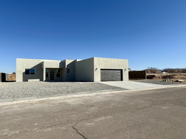 contemporary home with a garage, concrete driveway, and stucco siding