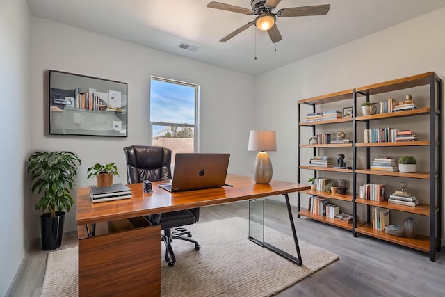 office featuring wood finished floors, visible vents, and a ceiling fan