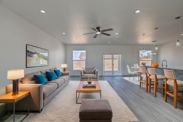 living area with recessed lighting, light wood-style flooring, a wealth of natural light, and a ceiling fan