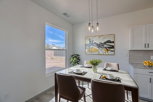 dining space with wood finished floors and visible vents