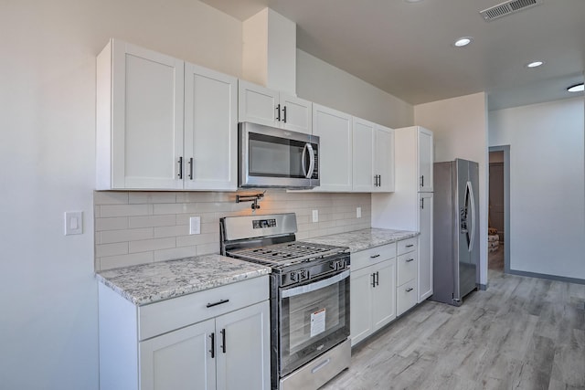 kitchen featuring light wood finished floors, visible vents, white cabinetry, and appliances with stainless steel finishes