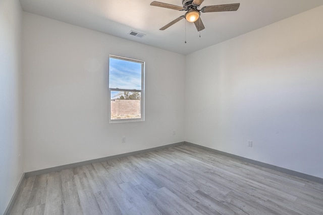 spare room featuring ceiling fan, baseboards, visible vents, and light wood-type flooring