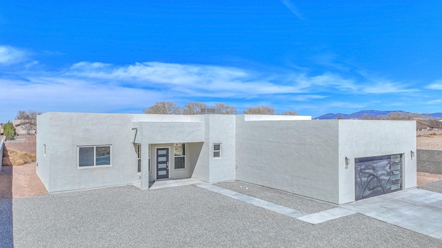 view of front of house featuring a garage, stucco siding, and a mountain view