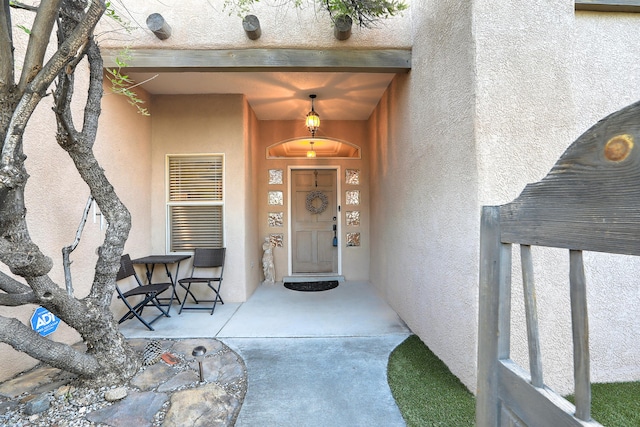 doorway to property featuring stucco siding