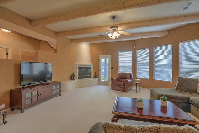 living area with carpet, visible vents, beam ceiling, ceiling fan, and a large fireplace