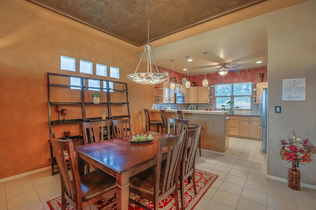 dining space with light tile patterned floors, a ceiling fan, and baseboards