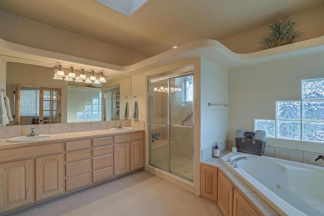 full bathroom featuring a sink, a whirlpool tub, double vanity, and a shower stall