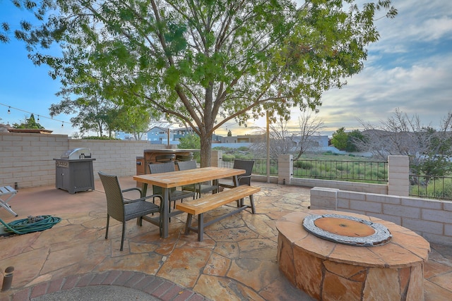 view of patio featuring outdoor dining space, a fire pit, and fence