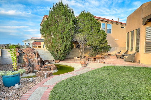 view of yard featuring a patio area, a fenced backyard, and a pergola