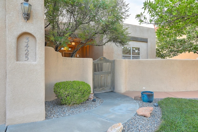 doorway to property with a gate and stucco siding