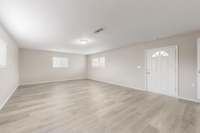 foyer featuring light wood finished floors, visible vents, and baseboards